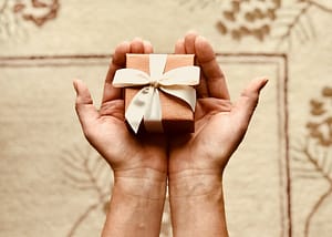 Hands holding a small brown gift box (hero image for Story Need article)