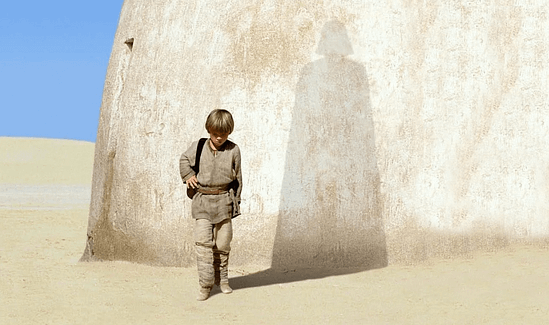 Young Anakin Skywalker projecting a shadow of Darth Vader